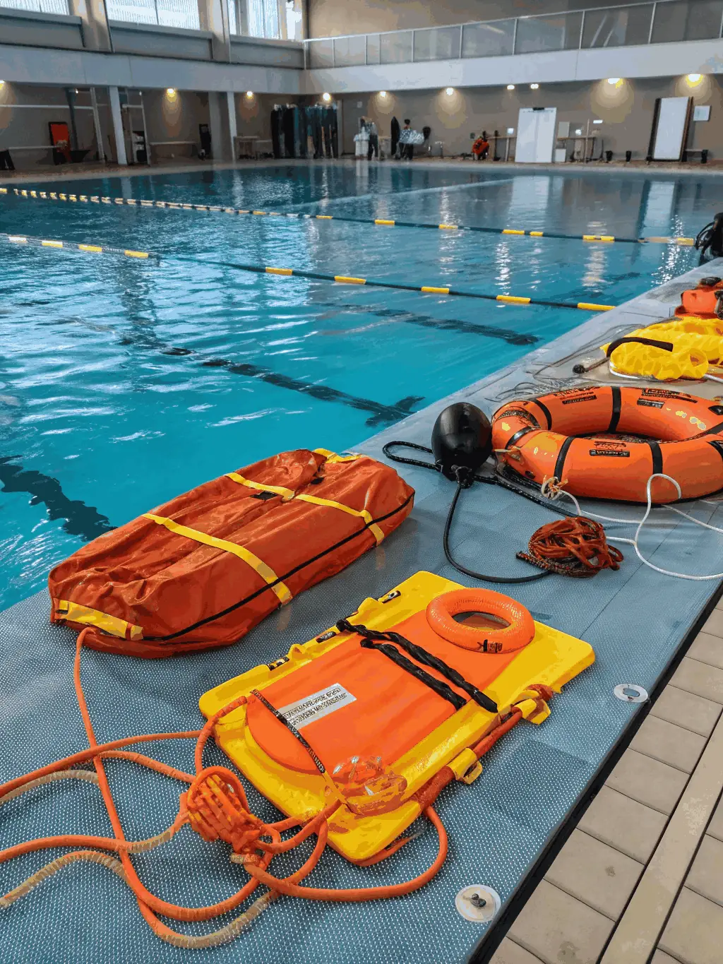 A dynamic image of a certified instructor demonstrating water rescue techniques to attentive participants at the poolside, with safety equipment visible, illustrating a hands-on aquatic safety workshop.